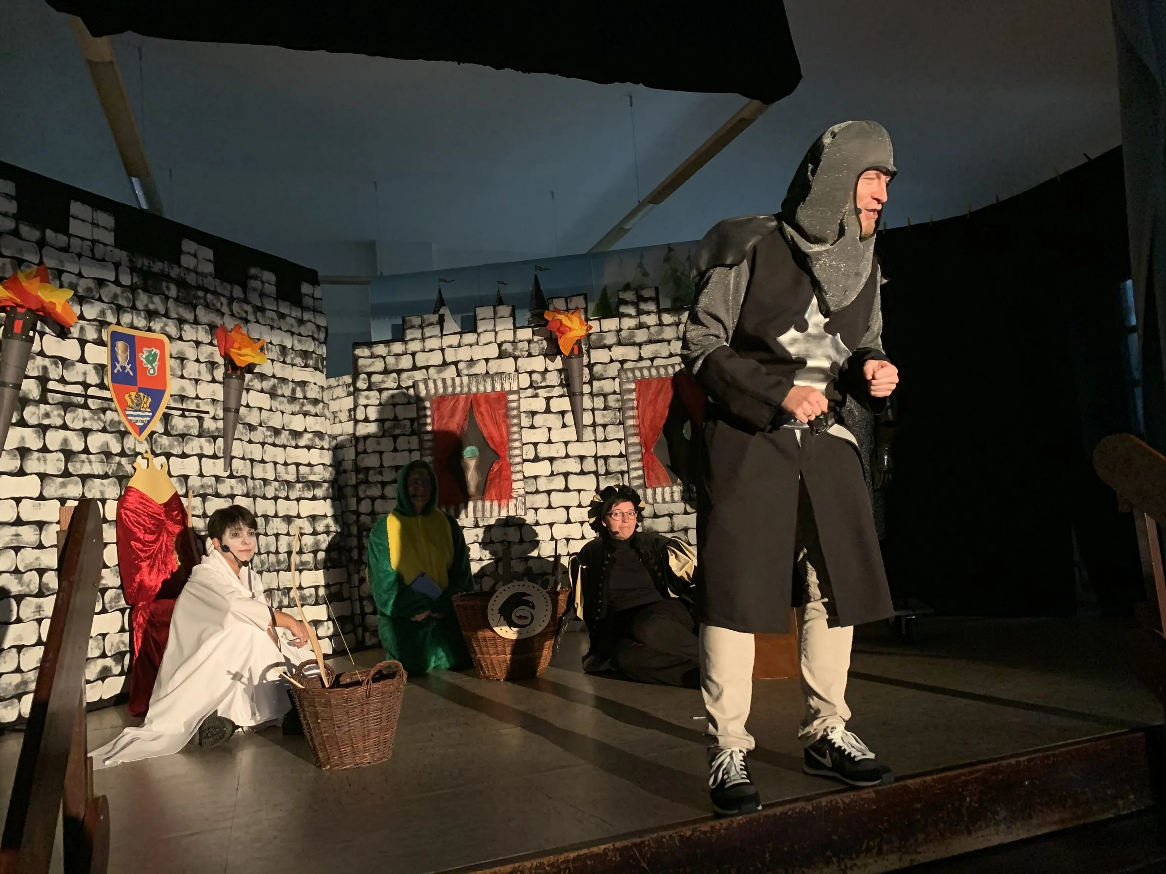 Ritter Lügenschreck vor der Burgkulisse, im Hintergrund kniend Drache Balduin und Gespenst Buhu sowie Knappe Mathes bei der Schatztruhe.