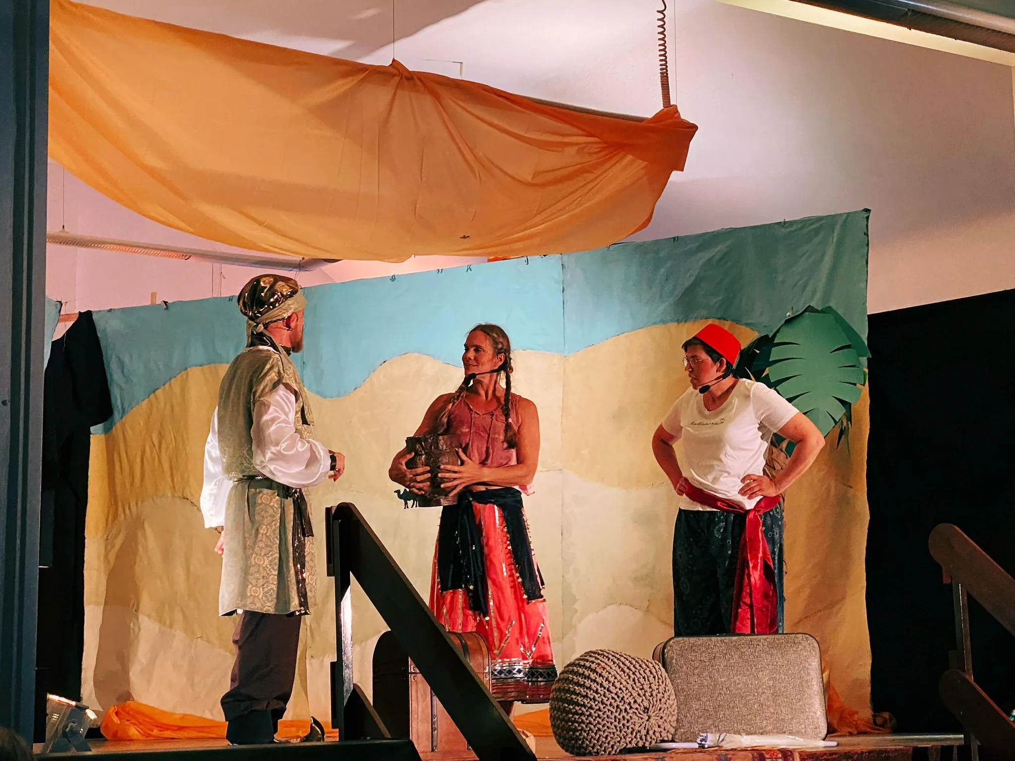 Sultan und eine Wache mit rotem Fes im Gespräch am Beistelltisch mit Krug und Bechern.