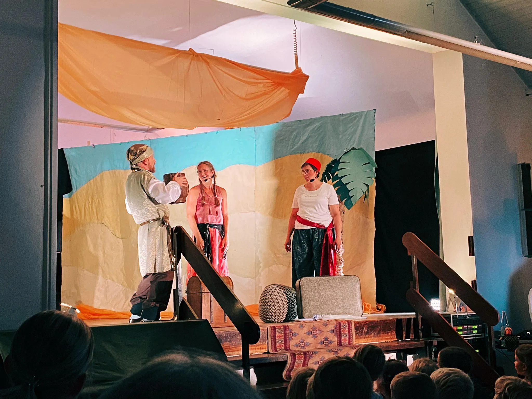 Mehrere Figuren kämpfen spielerisch im blauen Bühnenlicht vor dem Ensemble.