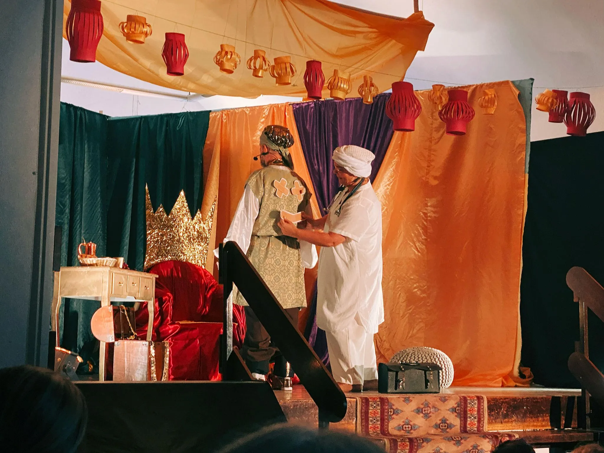 Der Sultan hebt grüßend die Hand vor dem goldenen Thron.
